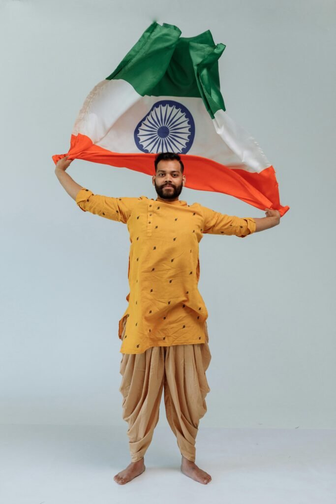 Portrait of an Indian man holding the national flag in traditional attire, celebrating Republic Day.